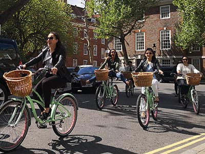 group of happy friends on bicycles in London